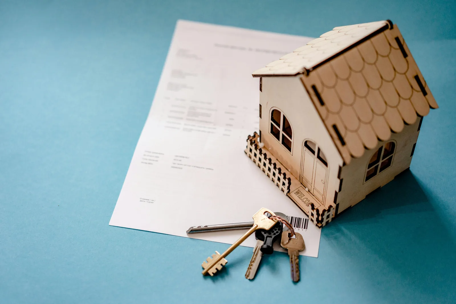 Maison miniature, clés et contrat illustrant la différence entre gestion locative et accompagnement LocPilot en location saisonnière