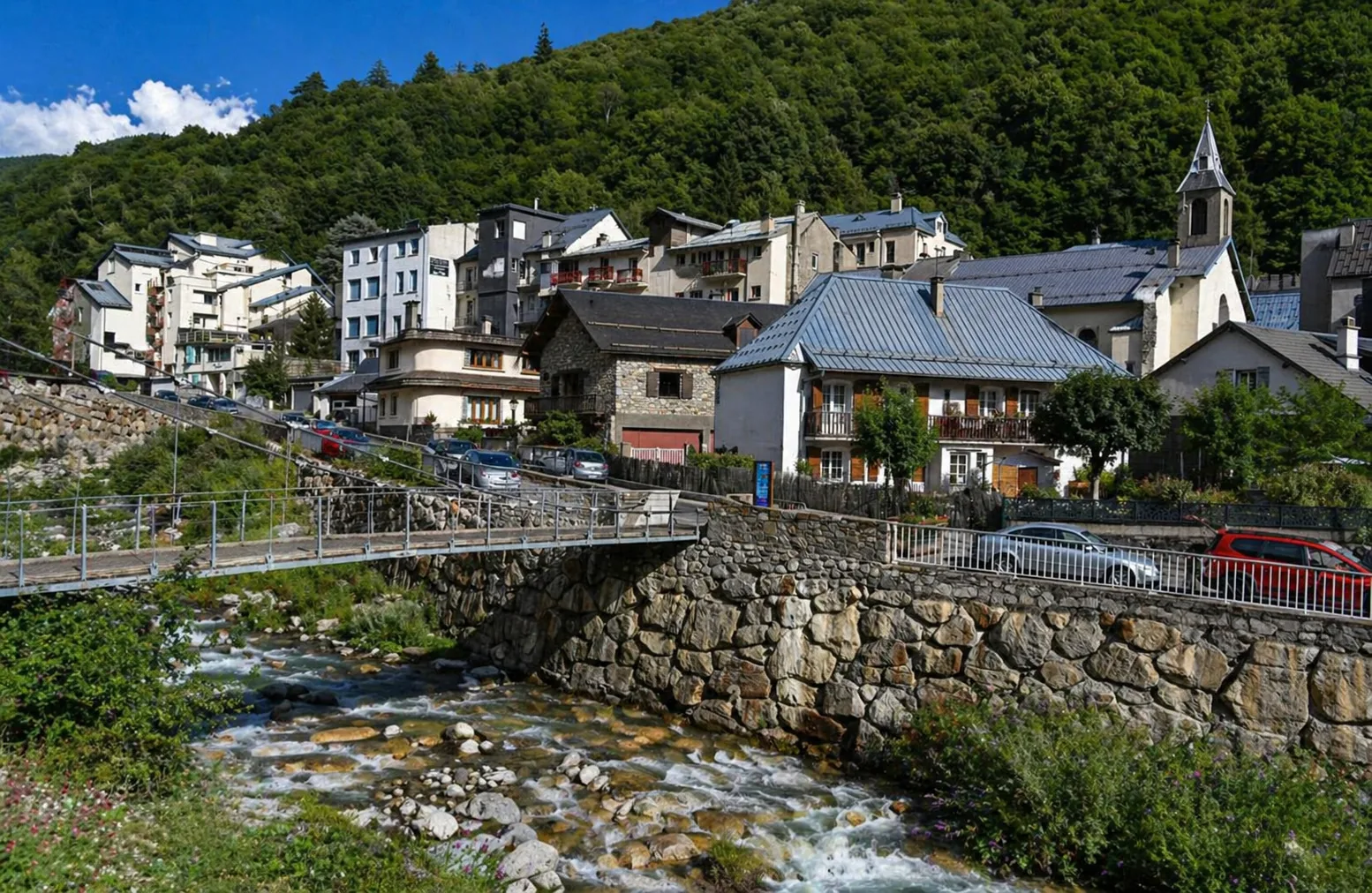 Vue du village de Barèges avec son église, ses maisons de montagne, le torrent du Bastan et le versant boisé des Hautes-Pyrénées